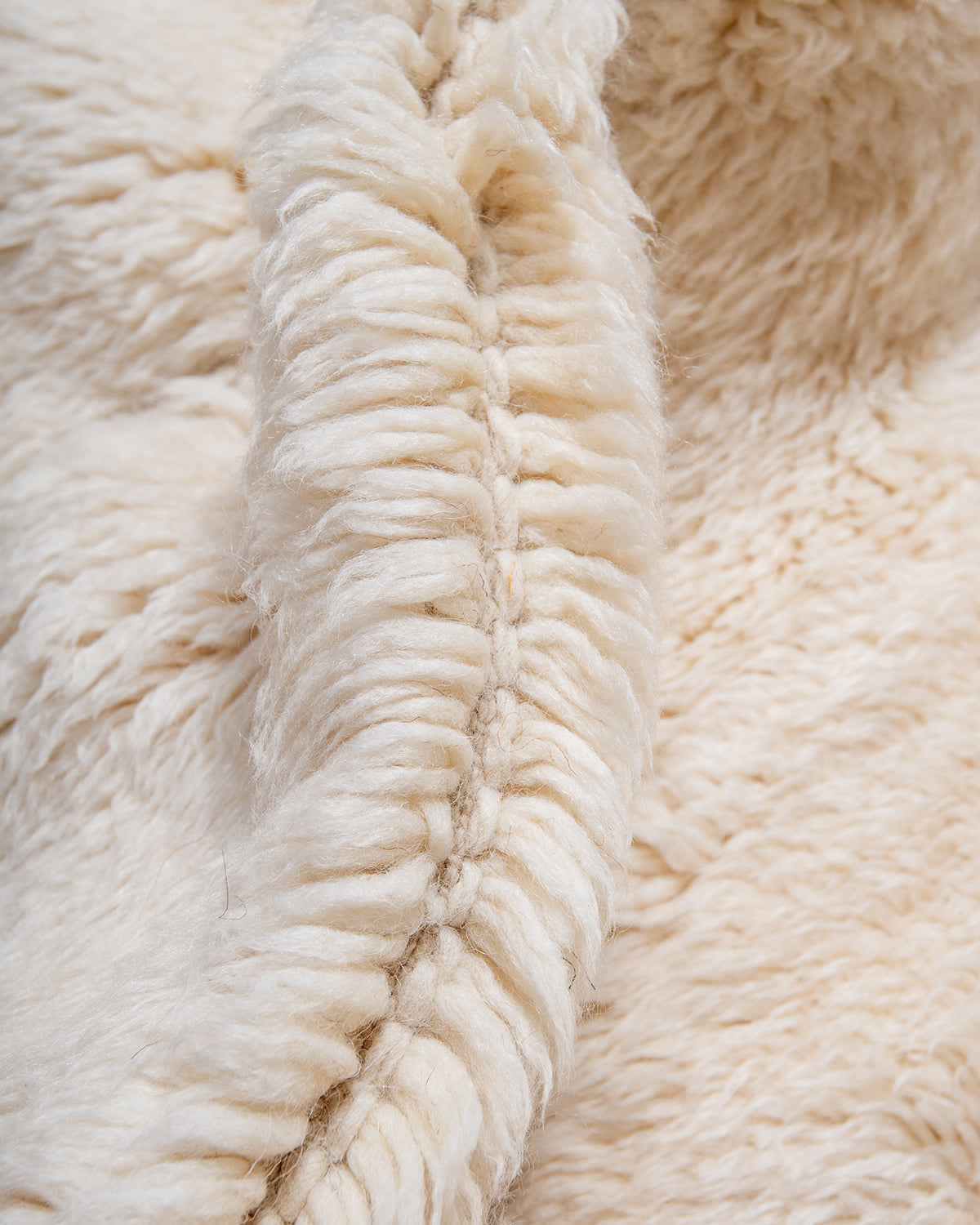 Close up of thick wool pile of cream Beni M'rirt rug.