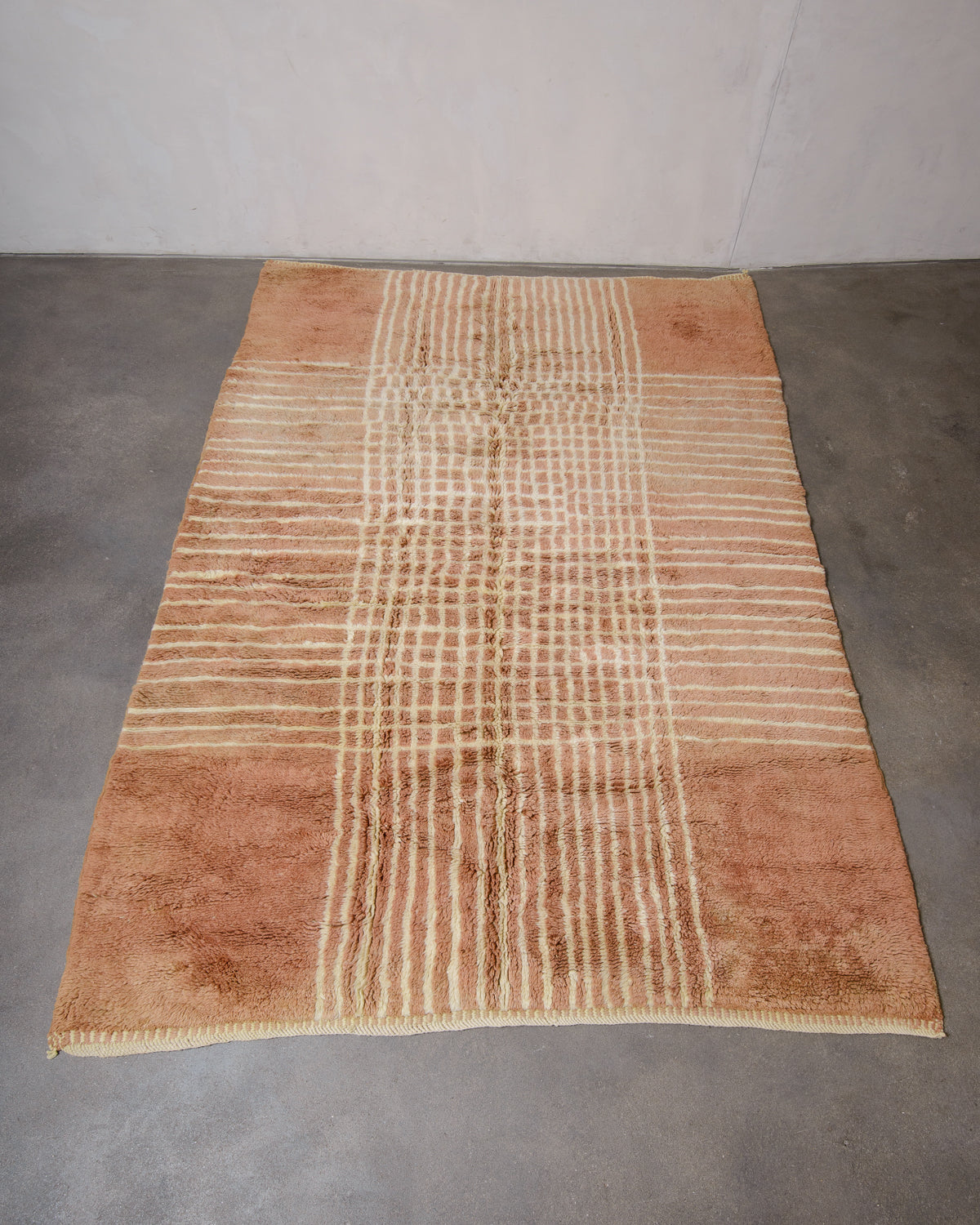 Berberlin Beni M'rirt rug in camel brown with lemon cream coloured grid pattern laying flat on concrete studio floor.
