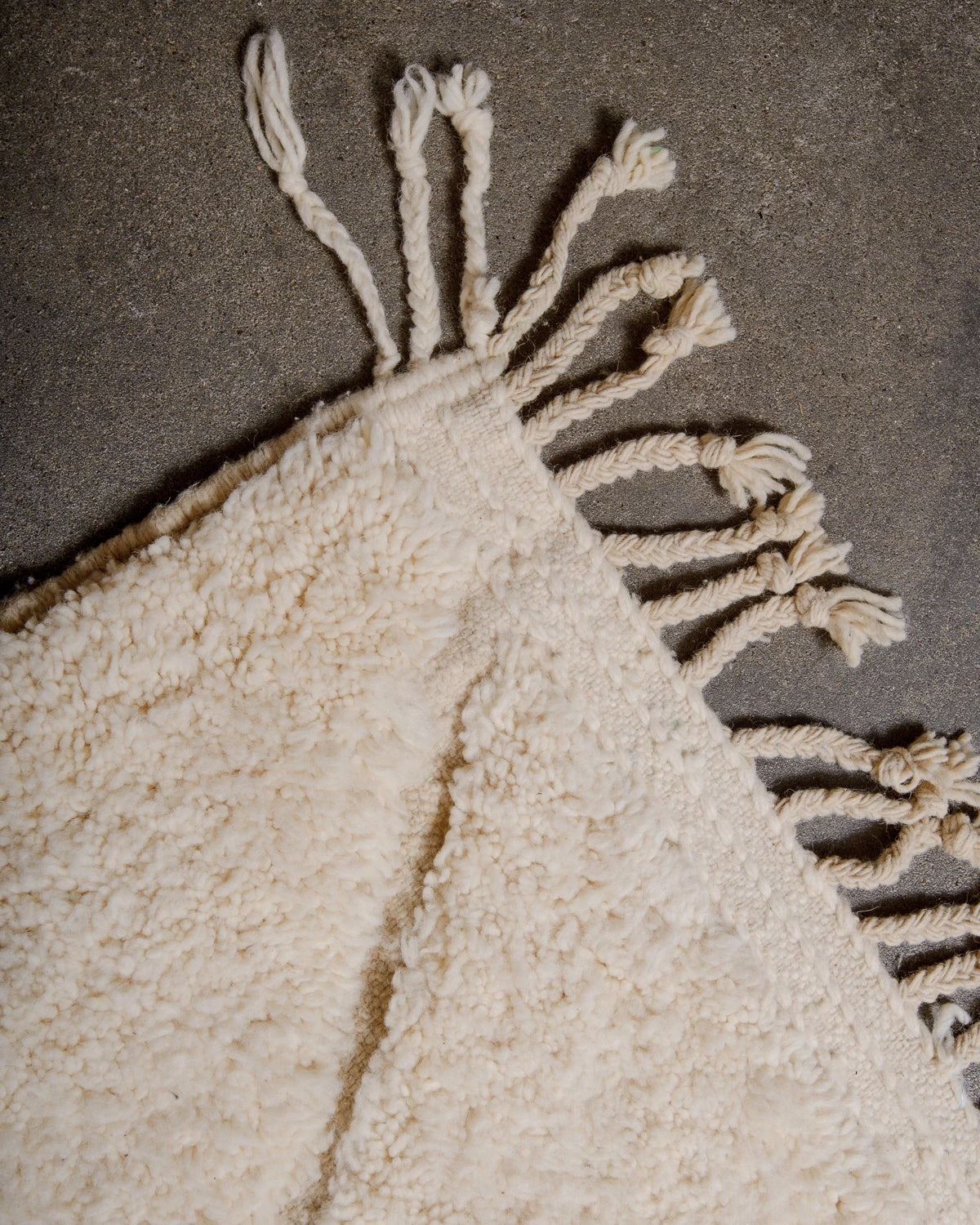 Natural wool tassels on a Berberlin Beniourain Rug made of natural cream wool with tightly woven ends.
