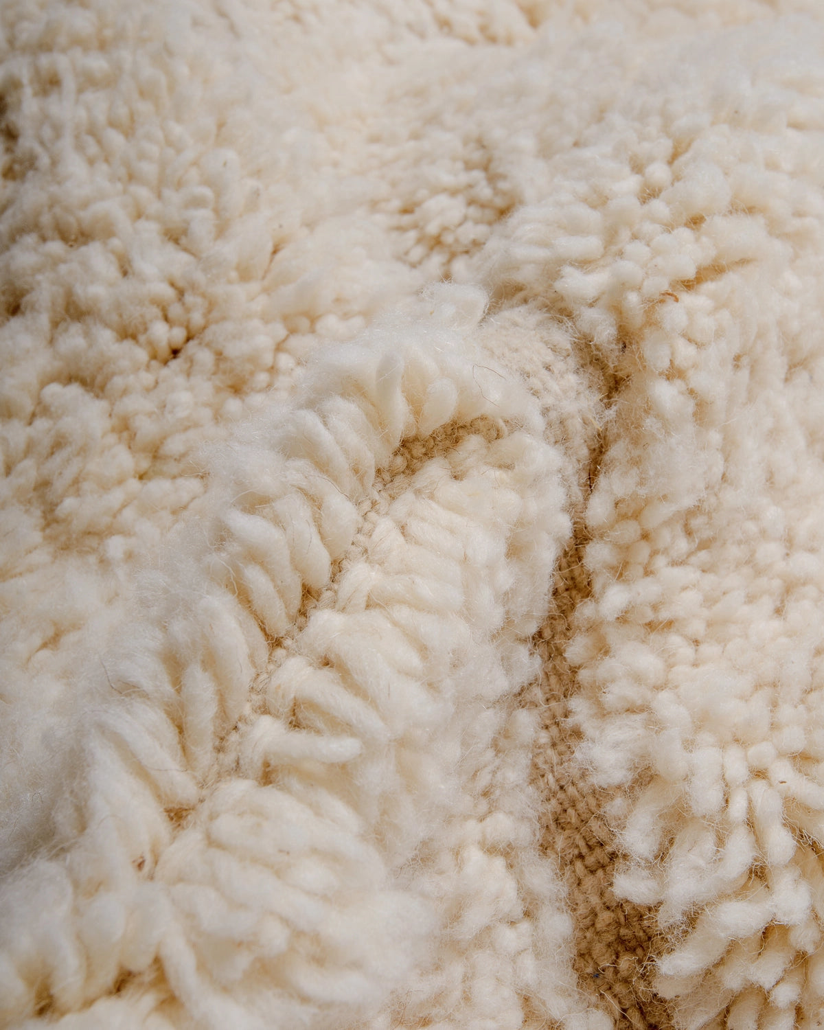 Detail of Berberlin Beniourain Rug made of natural cream wool.