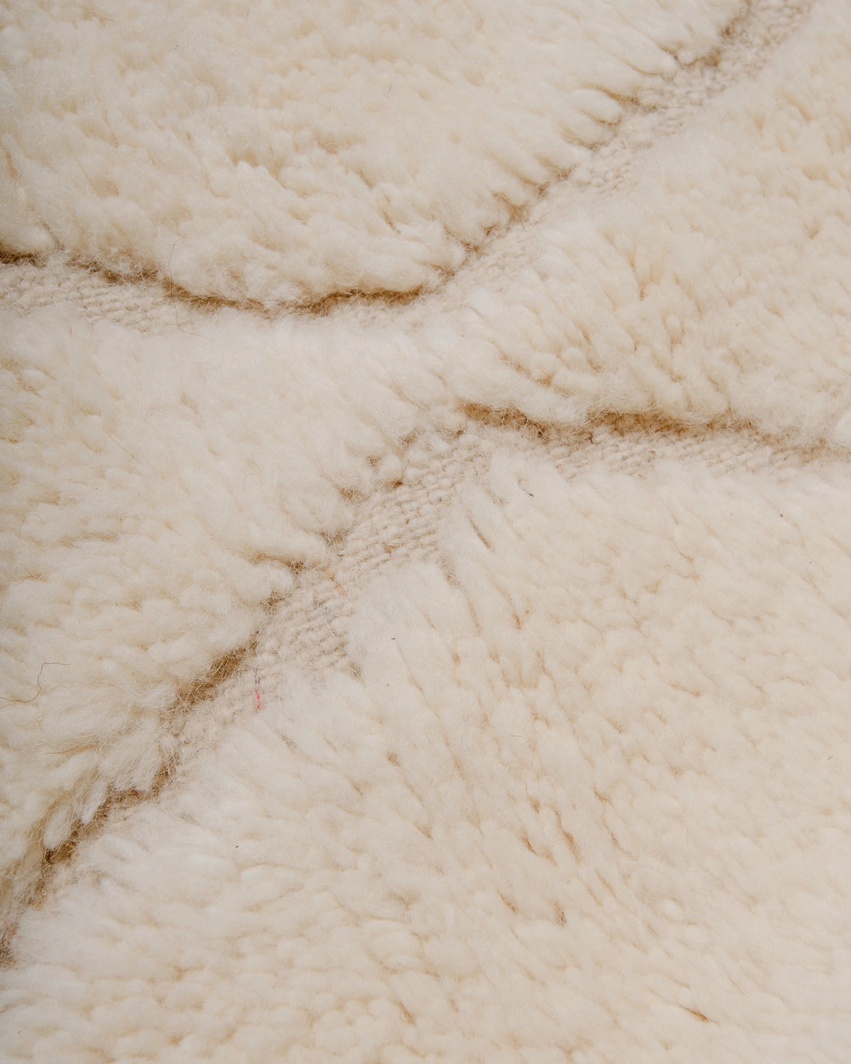 Detail of Berberlin Beniourain Rug made of natural cream wool.