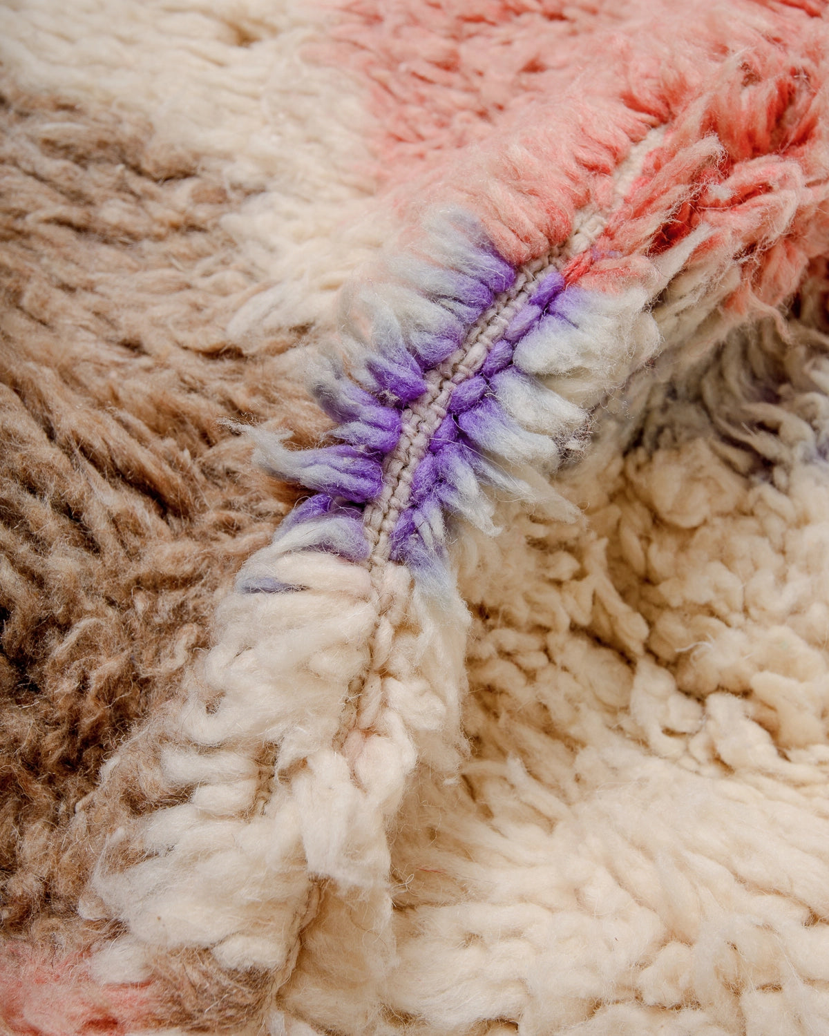 Detail of Berberlin Vintage Berber Rug made of fluffy cream, turquoise, brown, faded red and purple wool.
