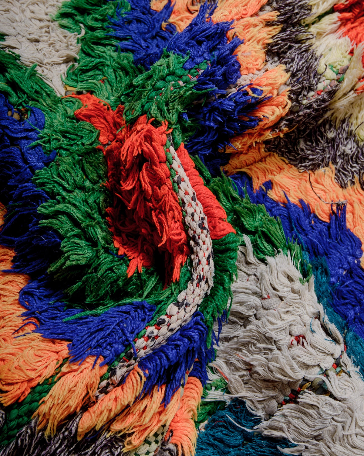 Detail of Berberlin Vintage Runner Rug made of recycled cloth and yarn in bright colours including blue, green, red and orange.