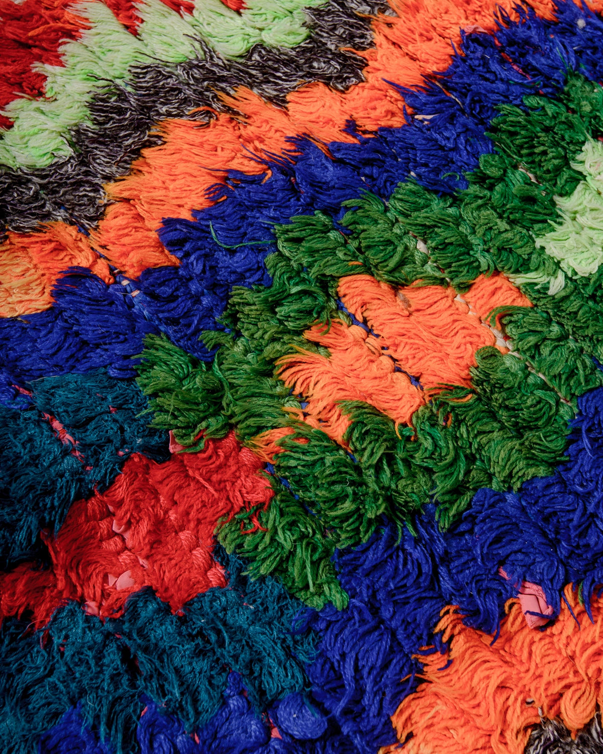 Detail of Berberlin Vintage Runner Rug made of recycled cloth and yarn in bright colours including blue, green, red and orange.