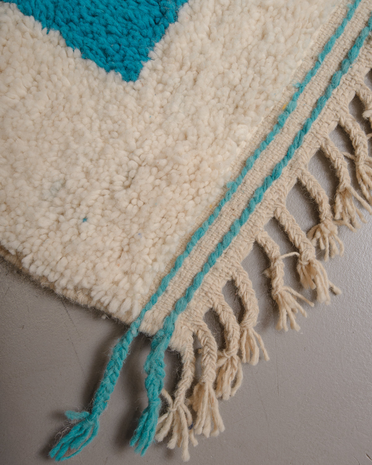 Corner of Berberlin rug with natural wool tassels along the edge.