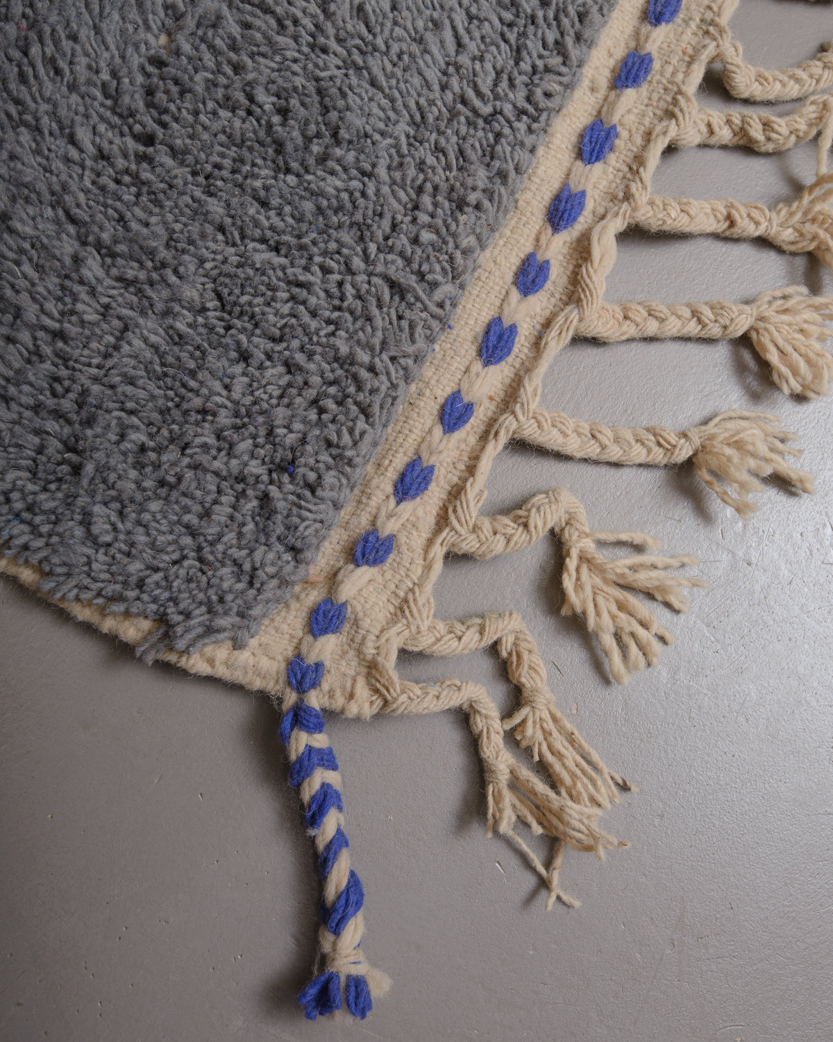 Corner of Berberlin rug with natural wool tassels.