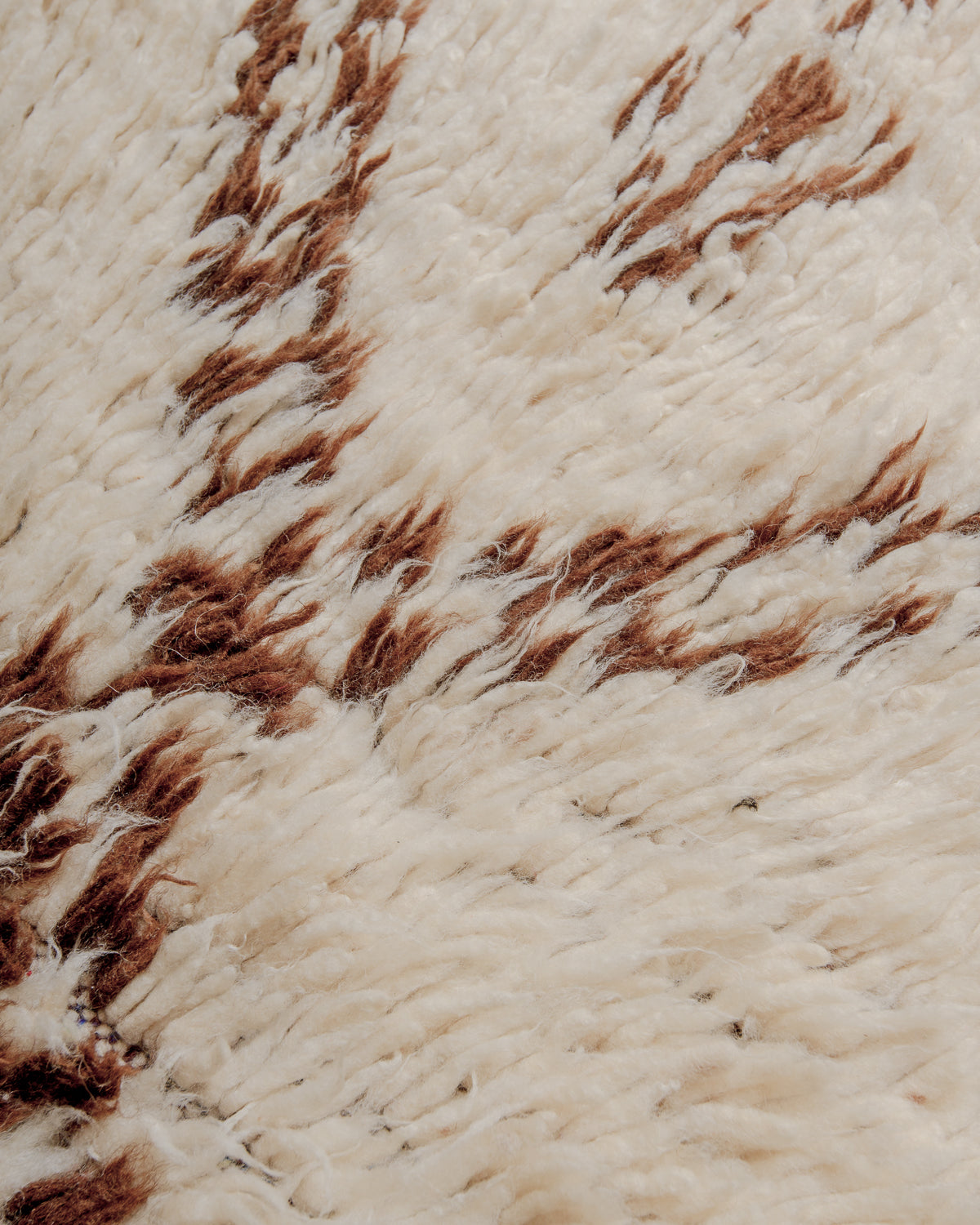 Close up of boucherouite rug surface with colourful brown and cream wool.