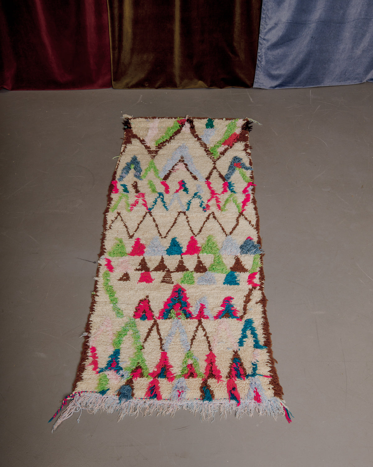 Vintage Berberlin boucherouite runner rug on grey floor.