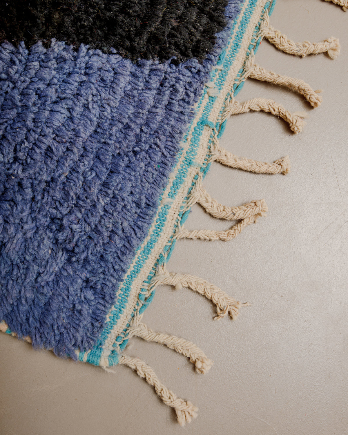 Edge of boujaad rug with natural wool tassels.