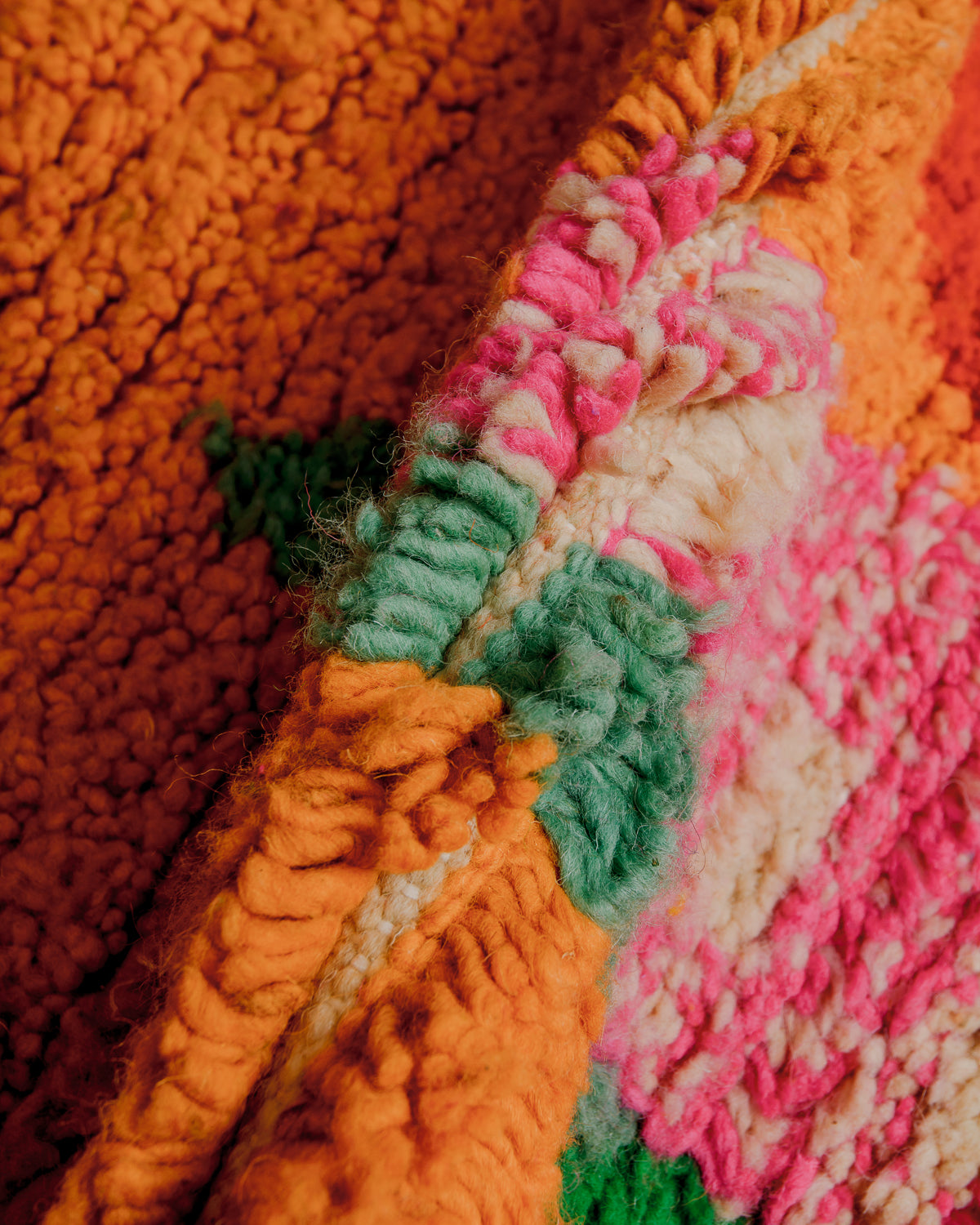 Texture of boujaad rug with orange, pink and turquoise wool.