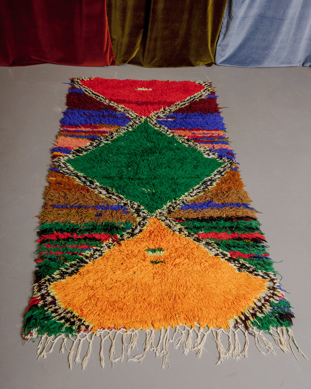 Vintage Berberlin boucherouite runner rug on grey floor.