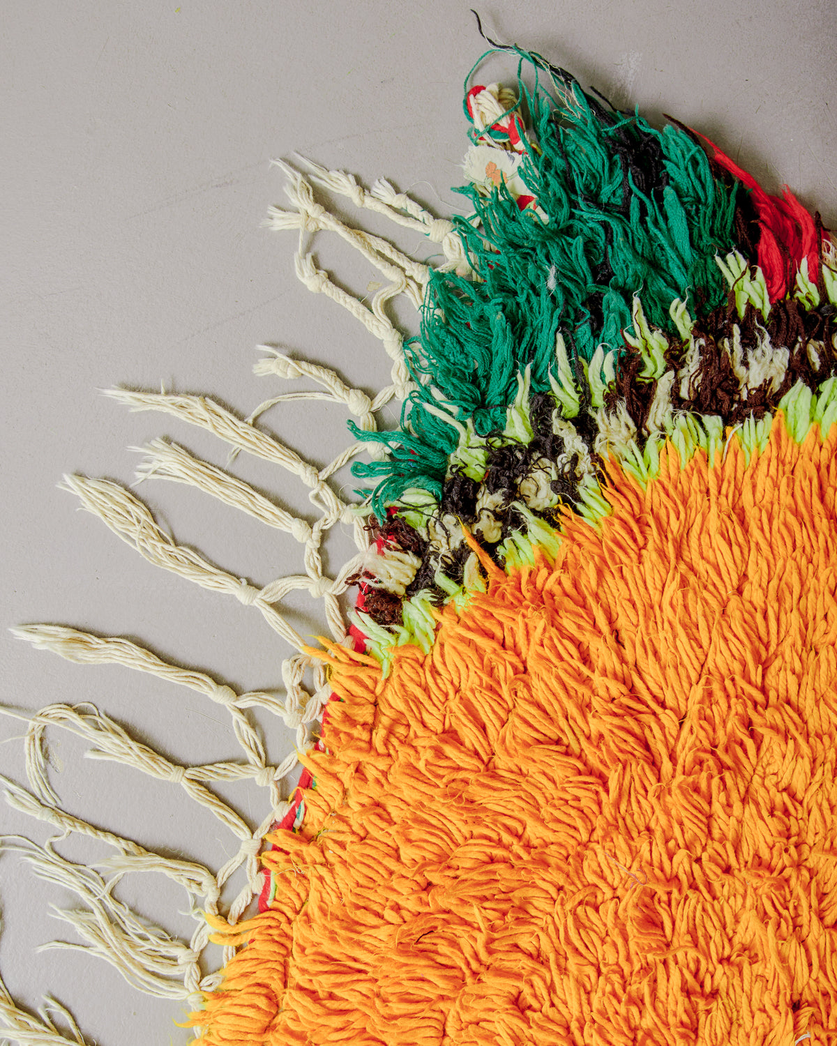 Corner of boucherouite rug with cotton tassels.