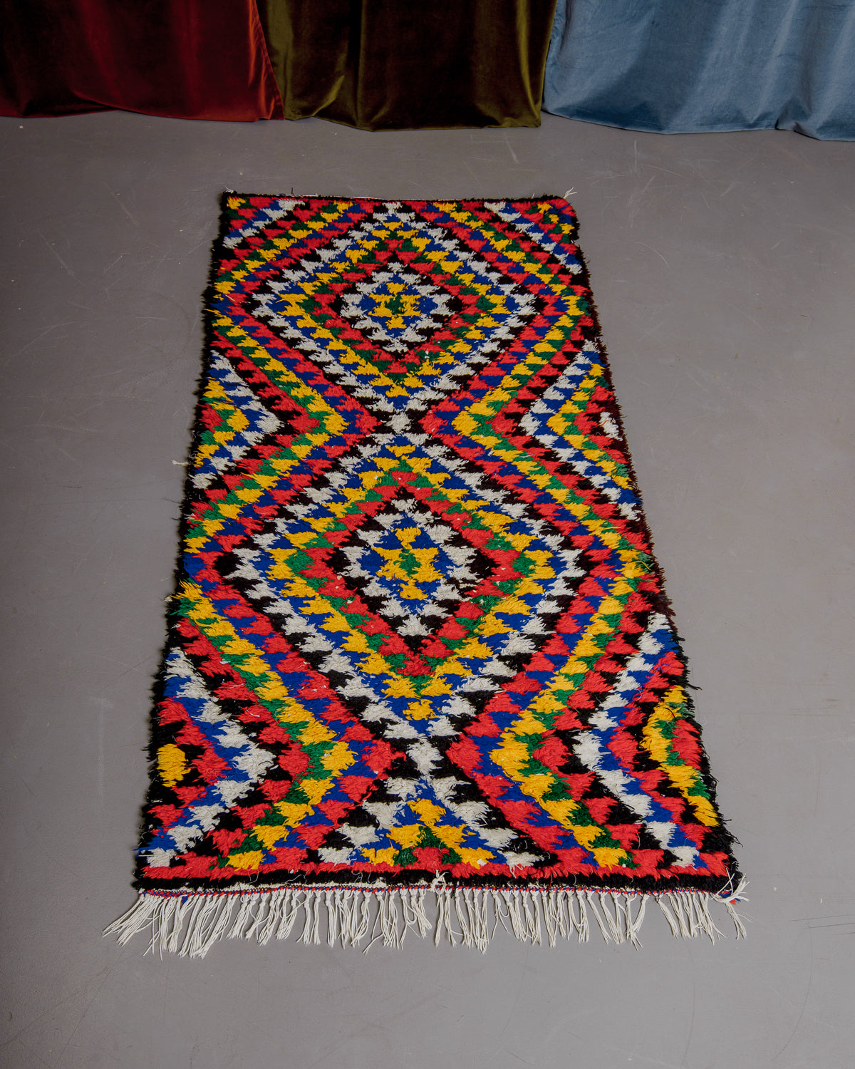 Vintage Berberlin boucherouite runner rug on grey floor.