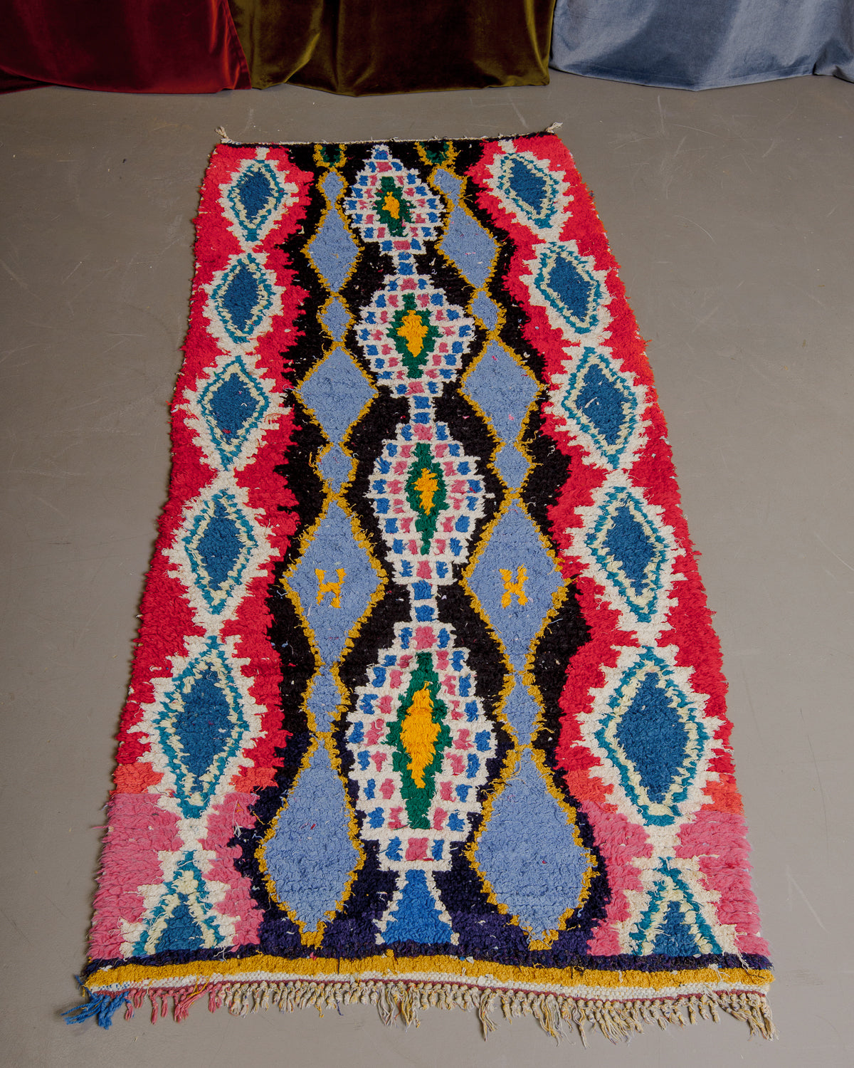 Vintage Berberlin boucherouite runner rug on grey floor.