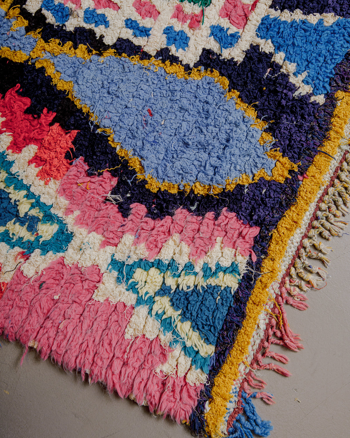 Corner of boucherouite rug with colourful cotton tassels.