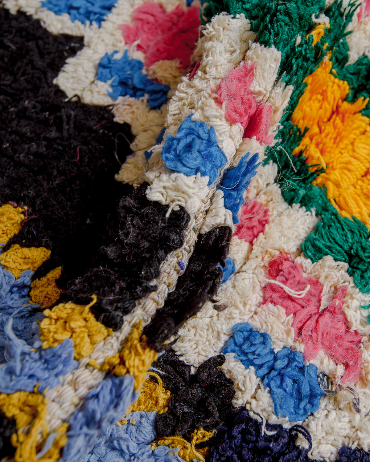 Close up of boucherouite rug surface with colourful cotton.