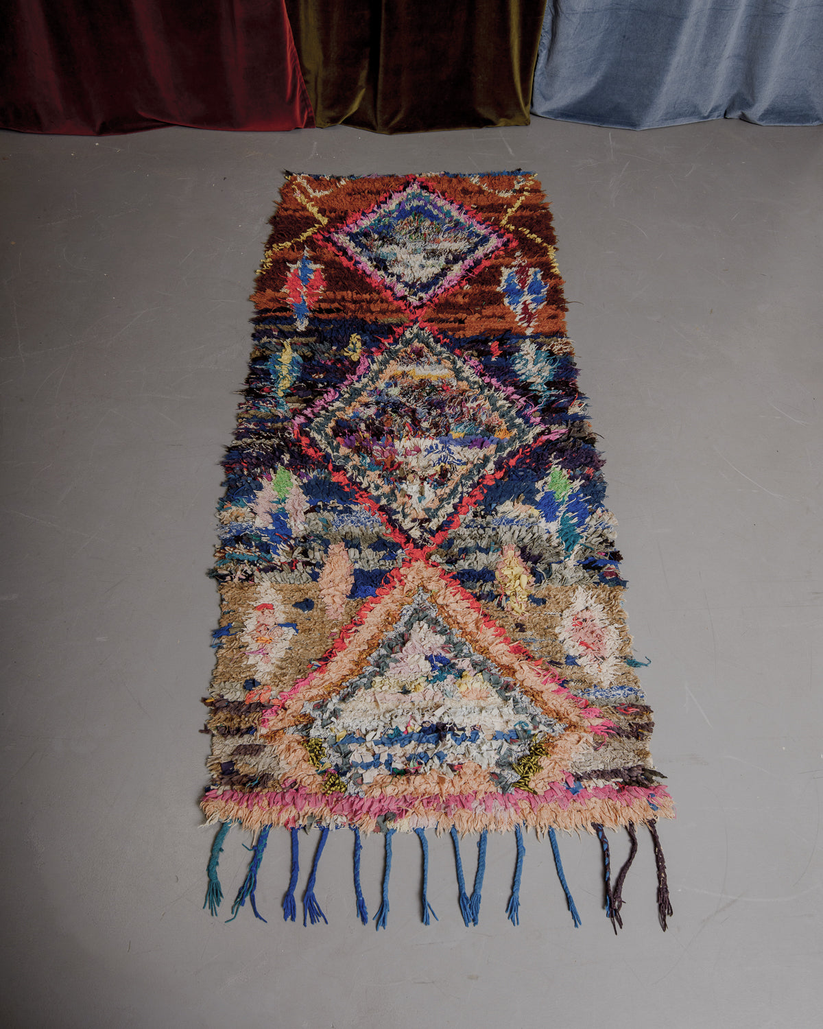 Vintage Berberlin boucherouite runner rug on grey floor.