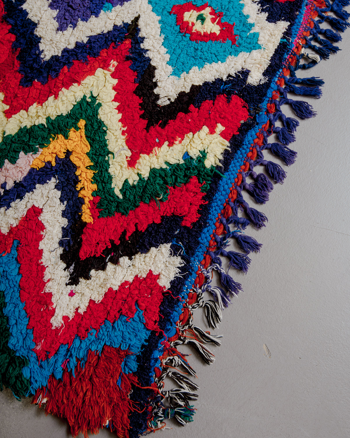 Edge of boucherouite rug with colourful cotton tassels.