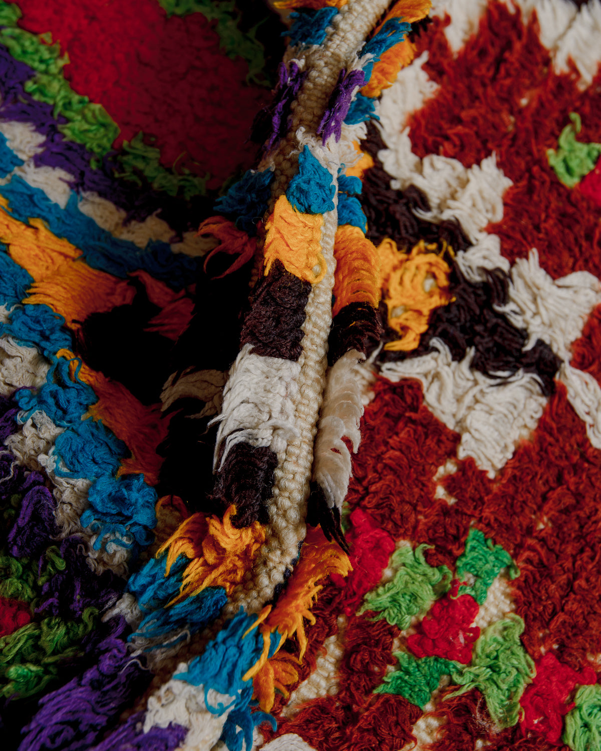 Close up of boucherouite rug surface with colourful cotton and wool.
