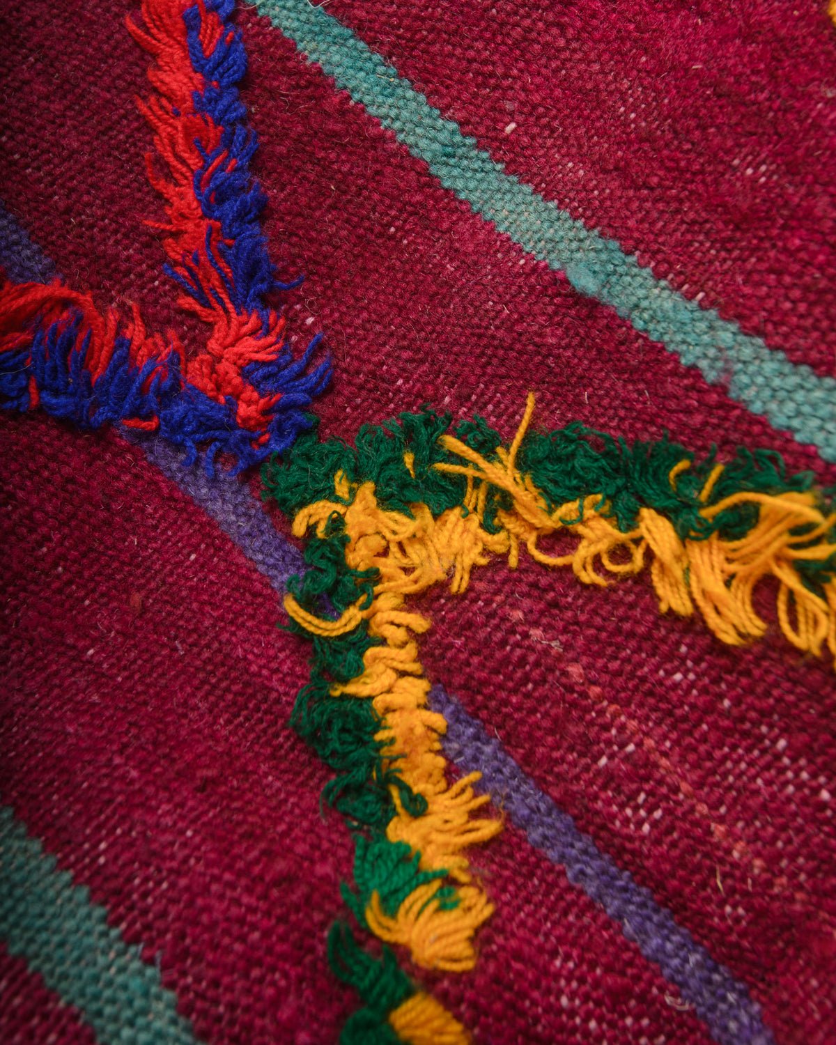 Surface of flat woven wool kelim rug with fluffy embroidered pattern.