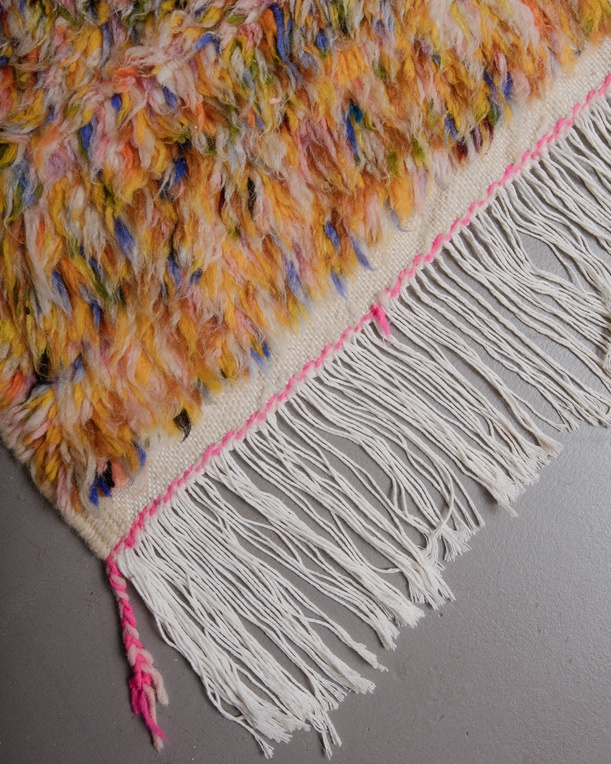 Corner of Berberlin azilal rug with white cotton fringe.