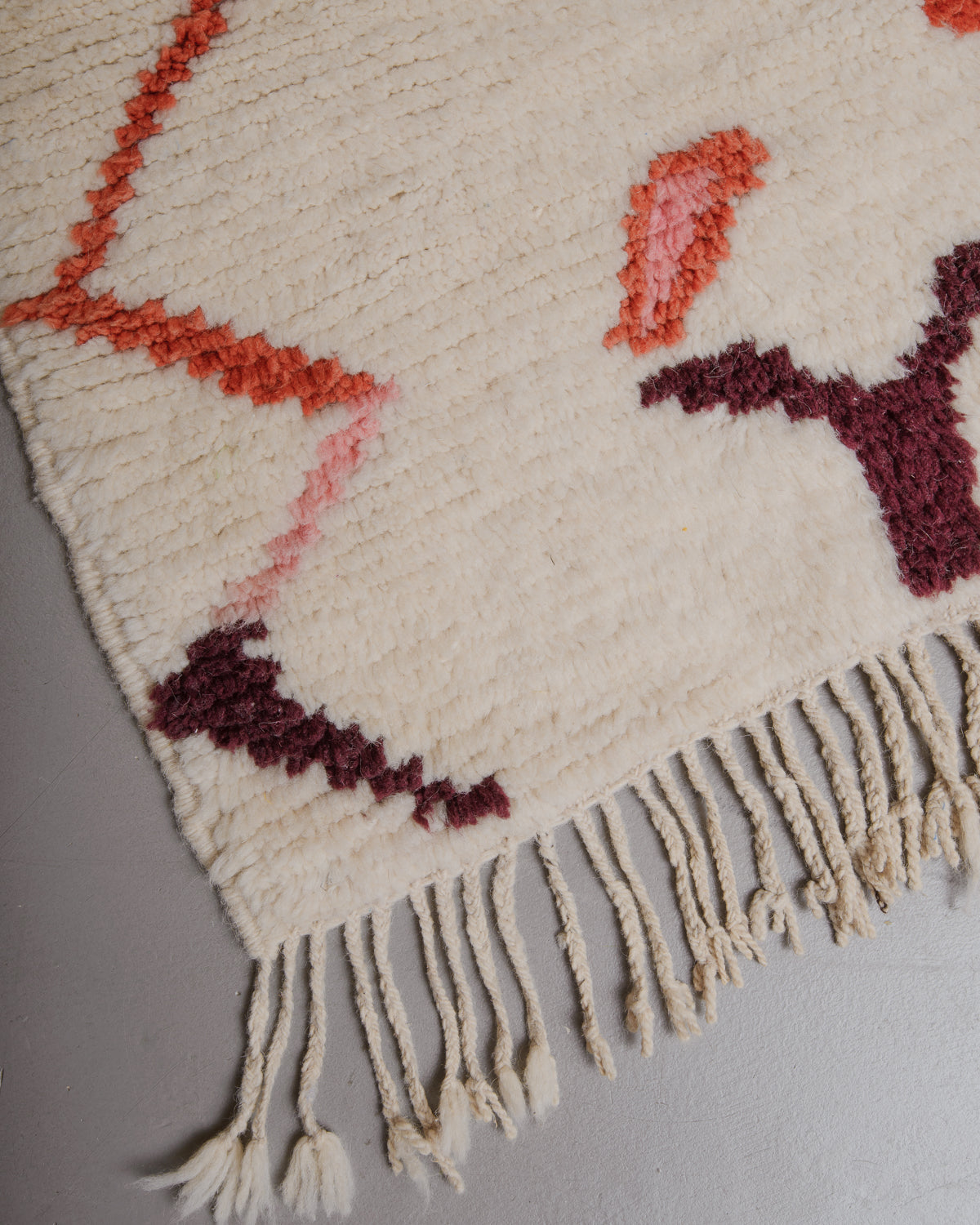 Corner of Berberlin azilal rug with natural wool tassels.
