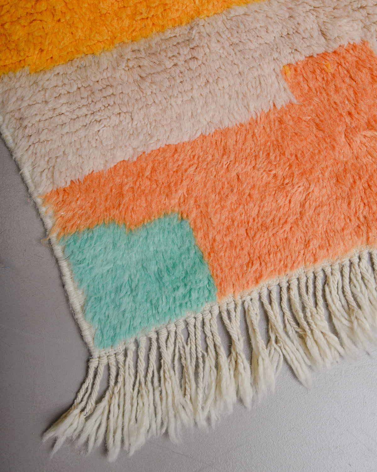 Corner of rug with natural wool tassels. 
