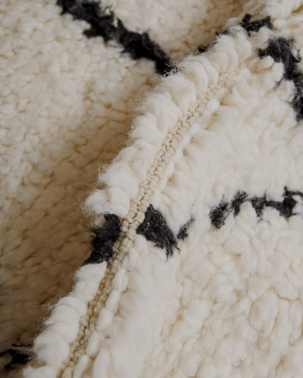 Fluffy cream wool pile with black lines.