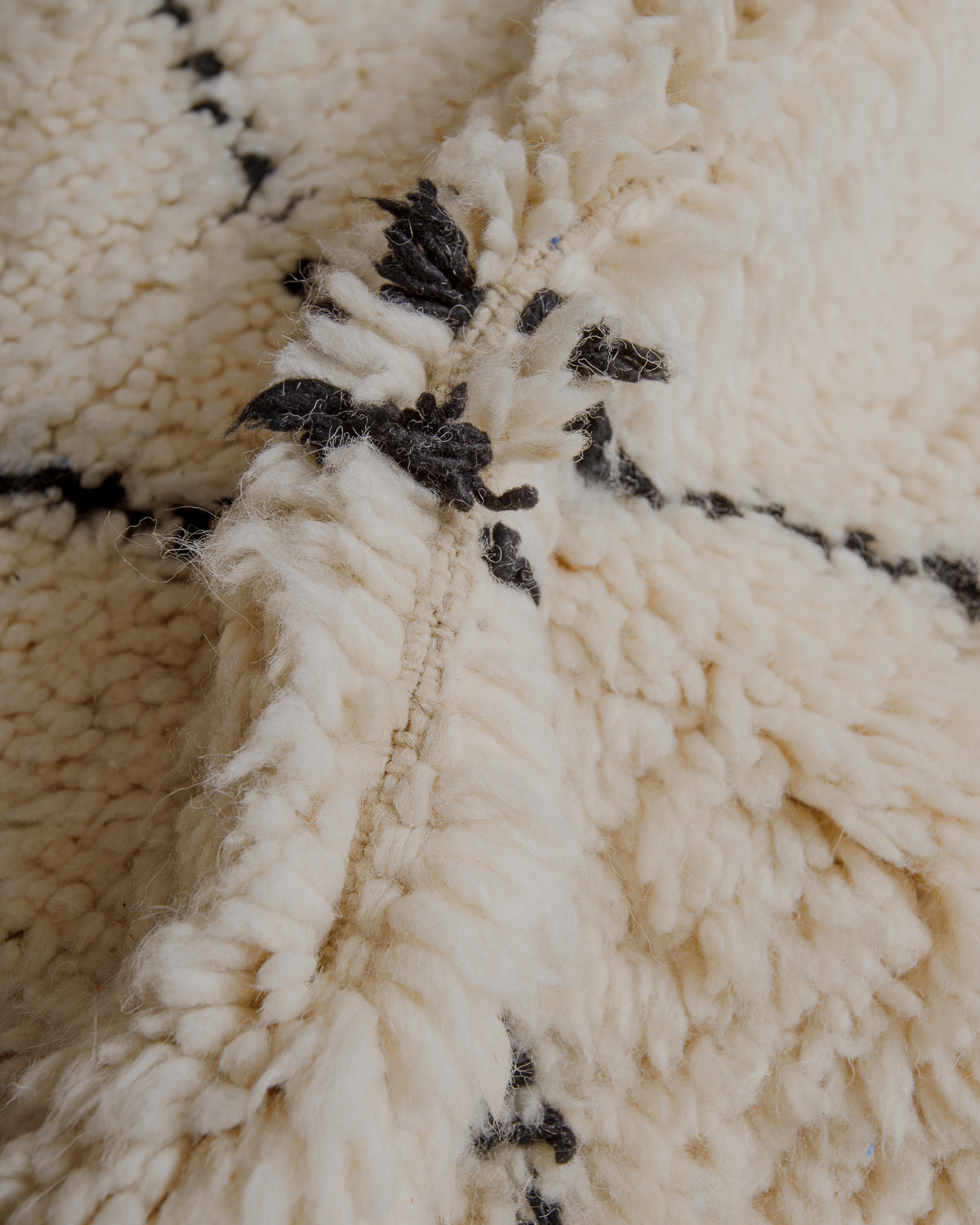Fluffy cream wool pile with black lines.