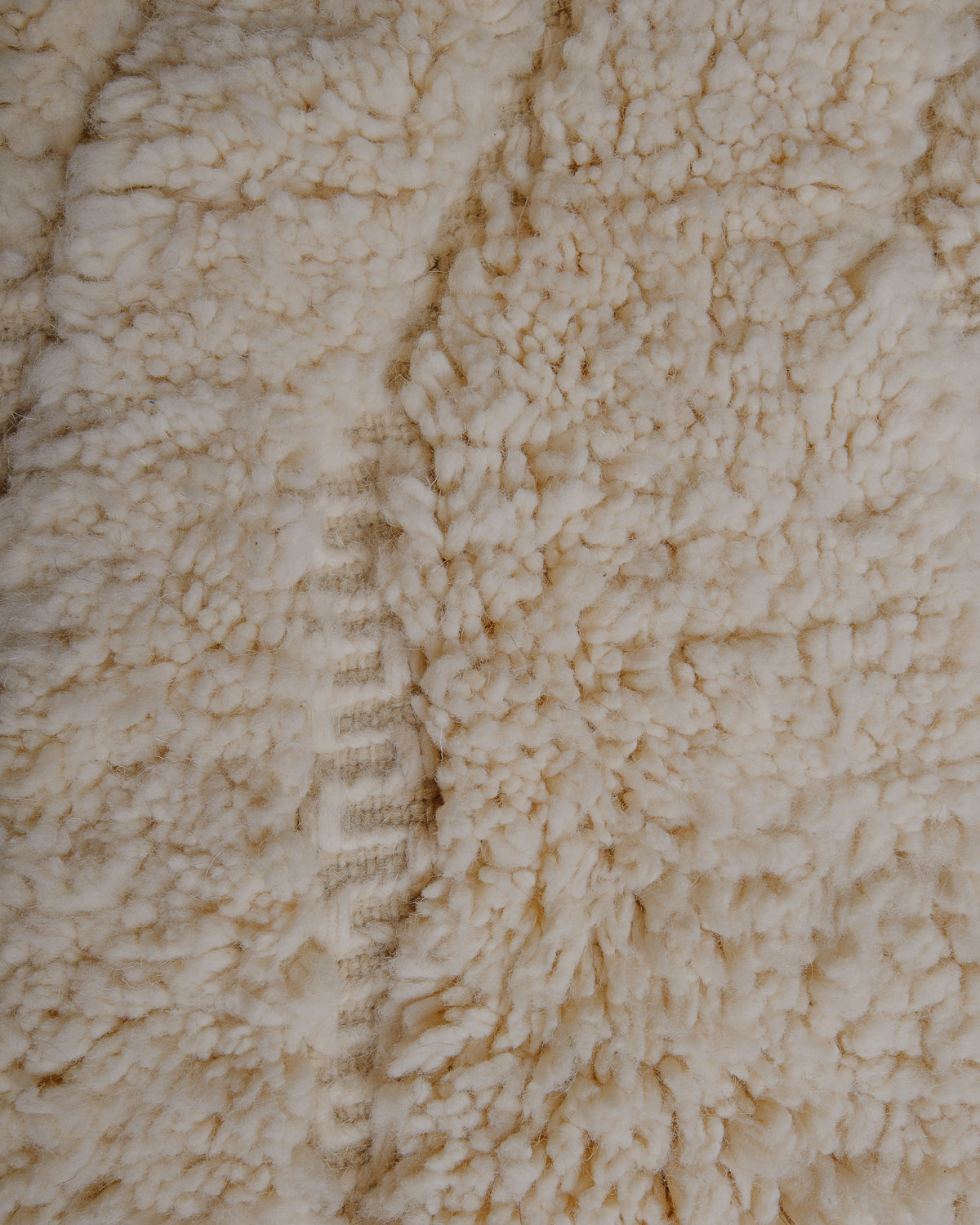 Fluffy cream wool pile with cream embroidered details.