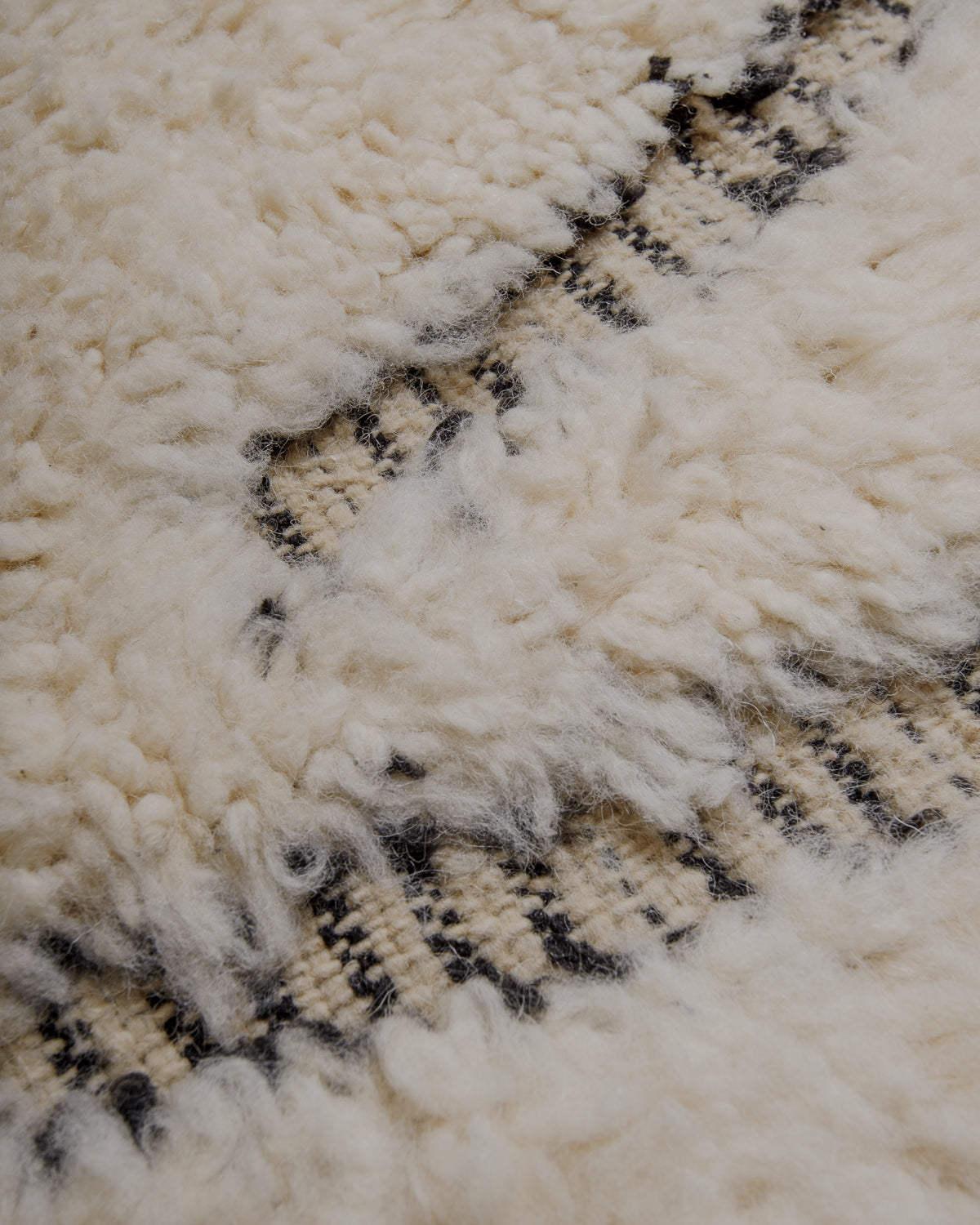 Fluffy cream wool pile with woven black stripes.