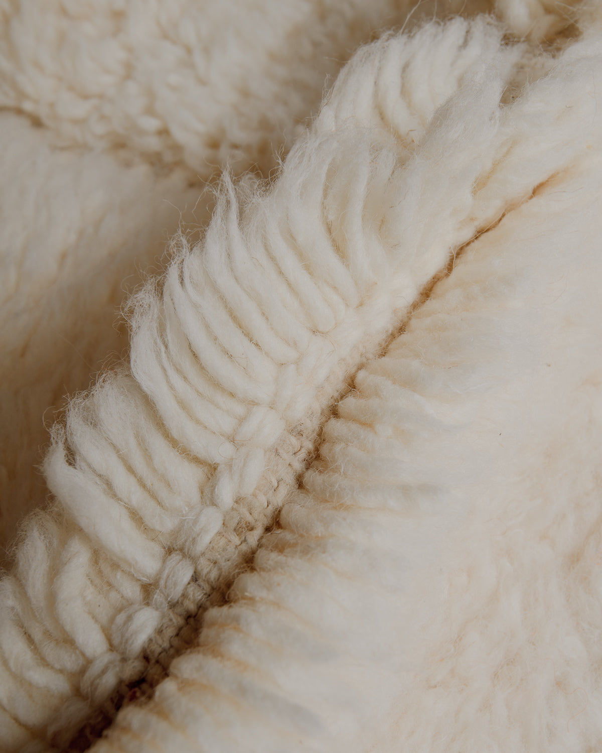 Fluffy cream wool pile and tight knots.