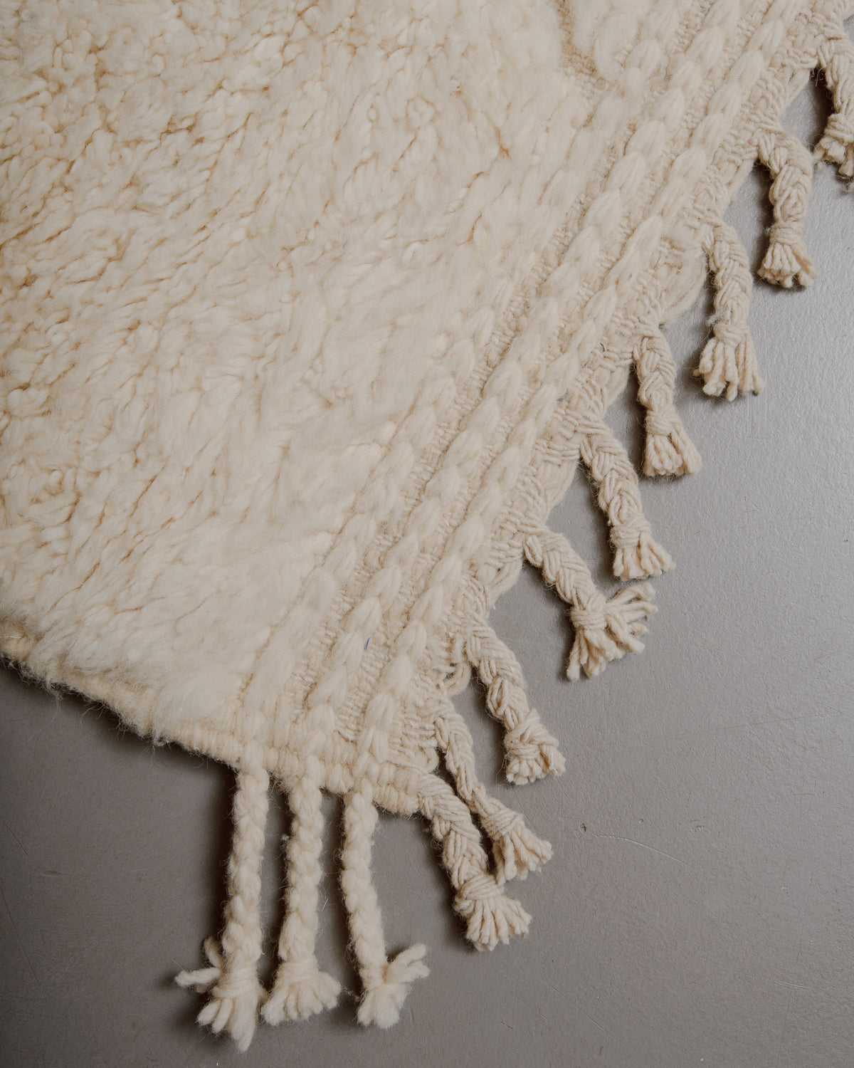 Edge of cream beniourain rug with natural wool tassels.