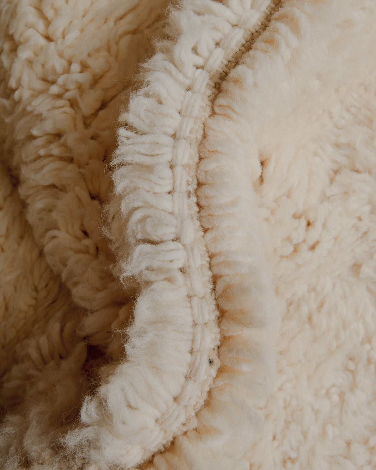 Fluffy cream wool pile and tight knots.