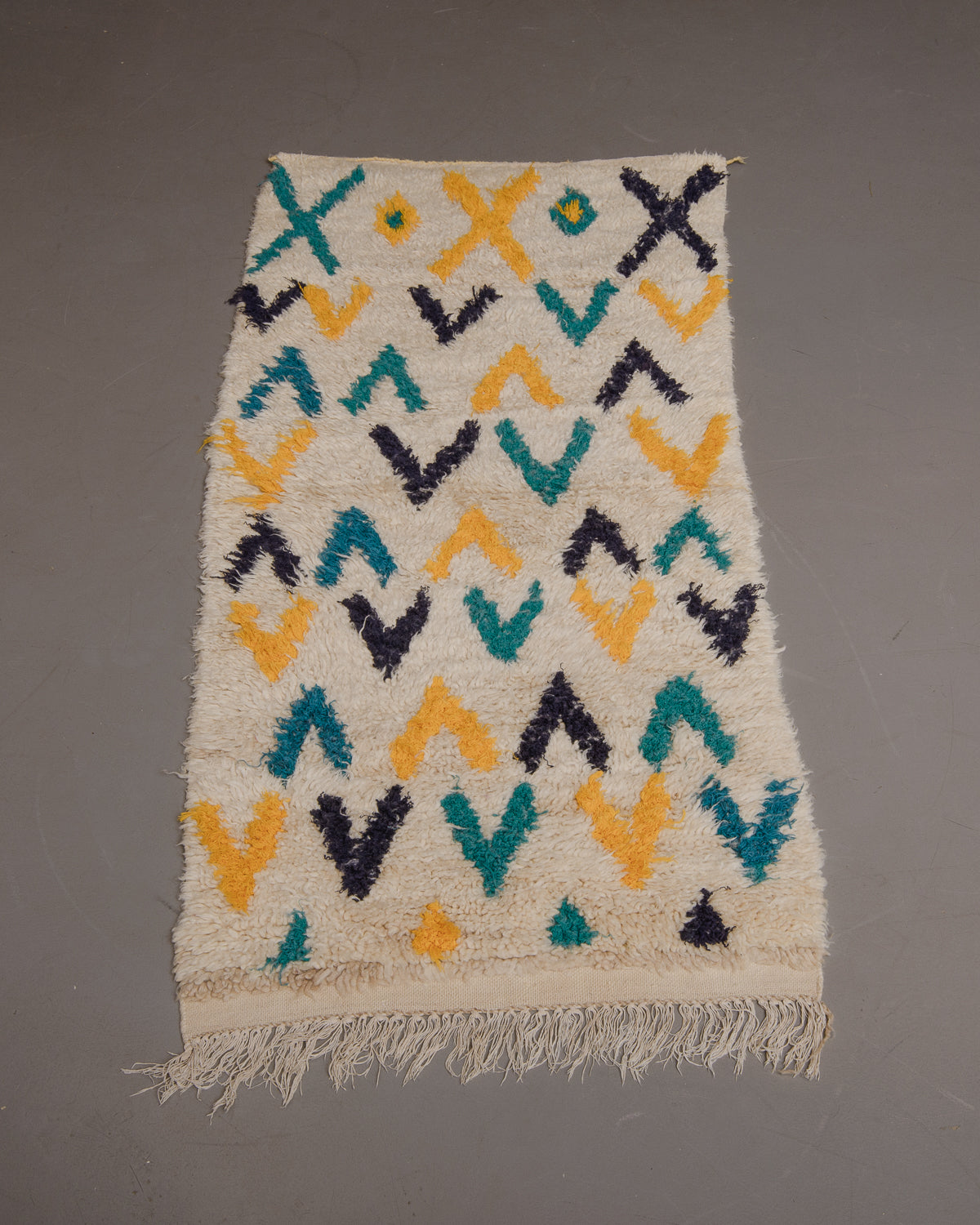 Vintage Berberlin boucherouite runner rug on grey floor.