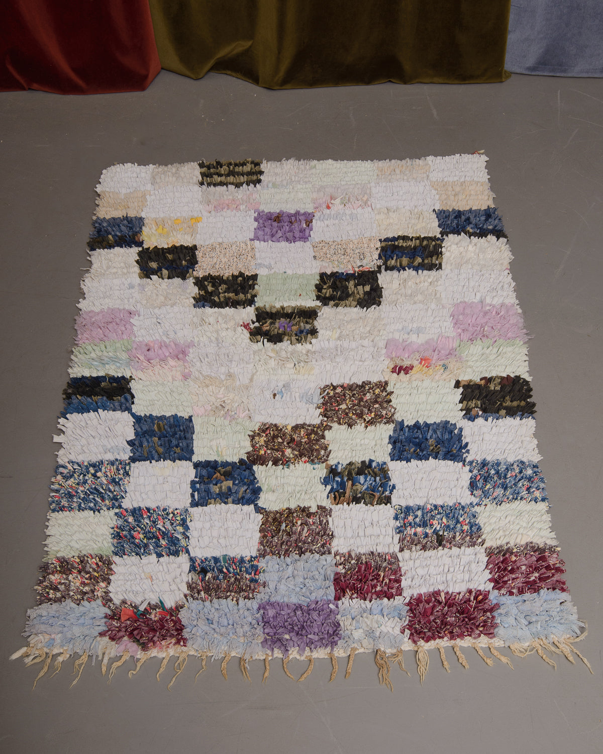 Vintage Berberlin boucherouite runner rug on grey floor.