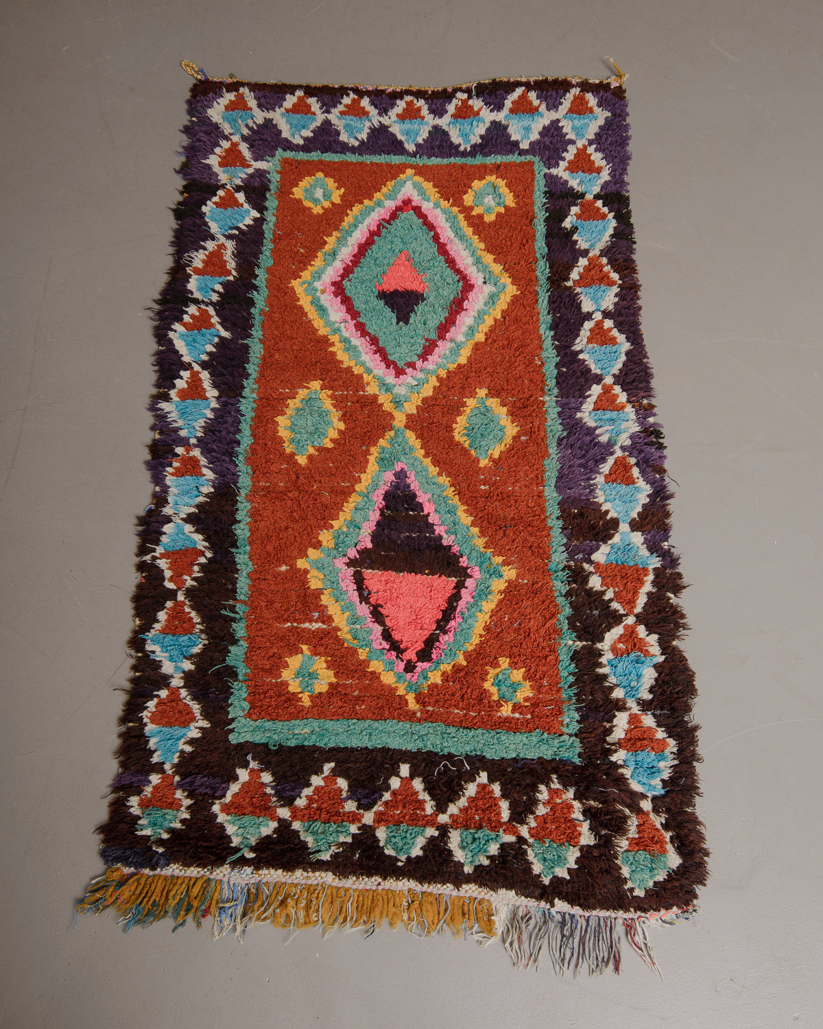 Vintage Berberlin boucherouite runner rug on grey floor.