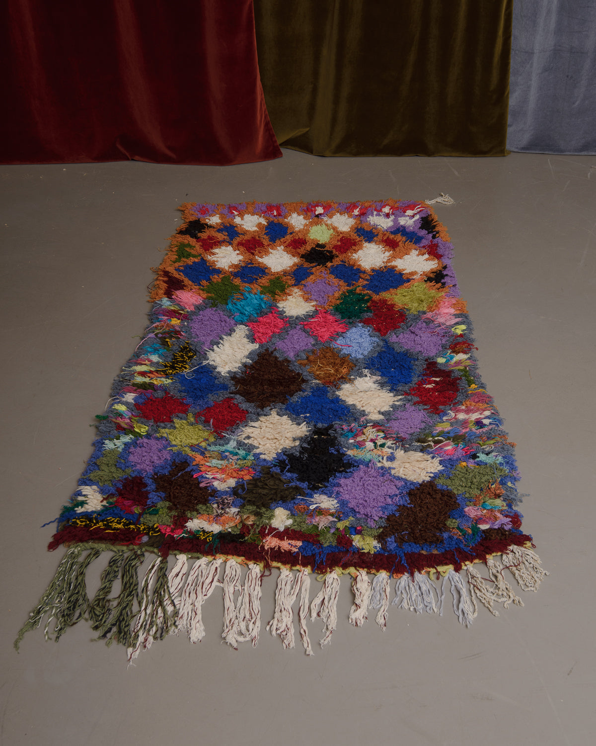 Vintage Berberlin boucherouite runner rug on grey floor.