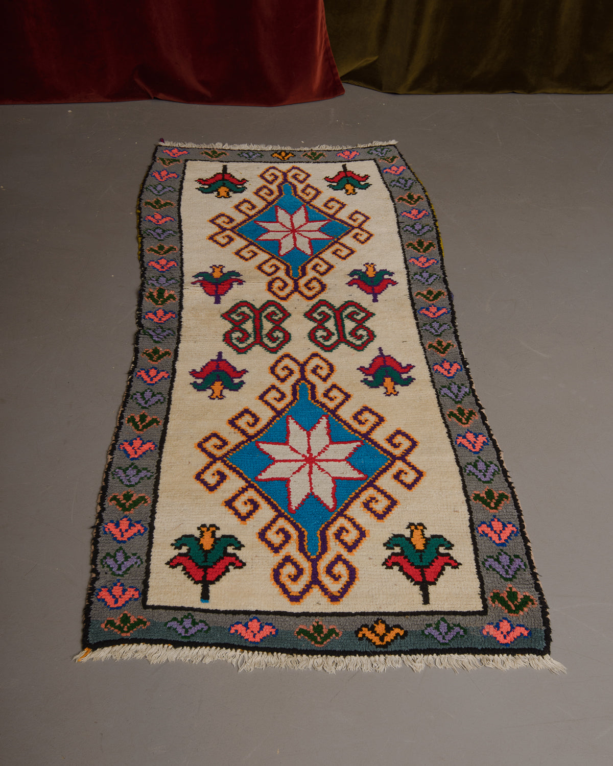 Vintage Berberlin boucherouite runner rug on grey floor.