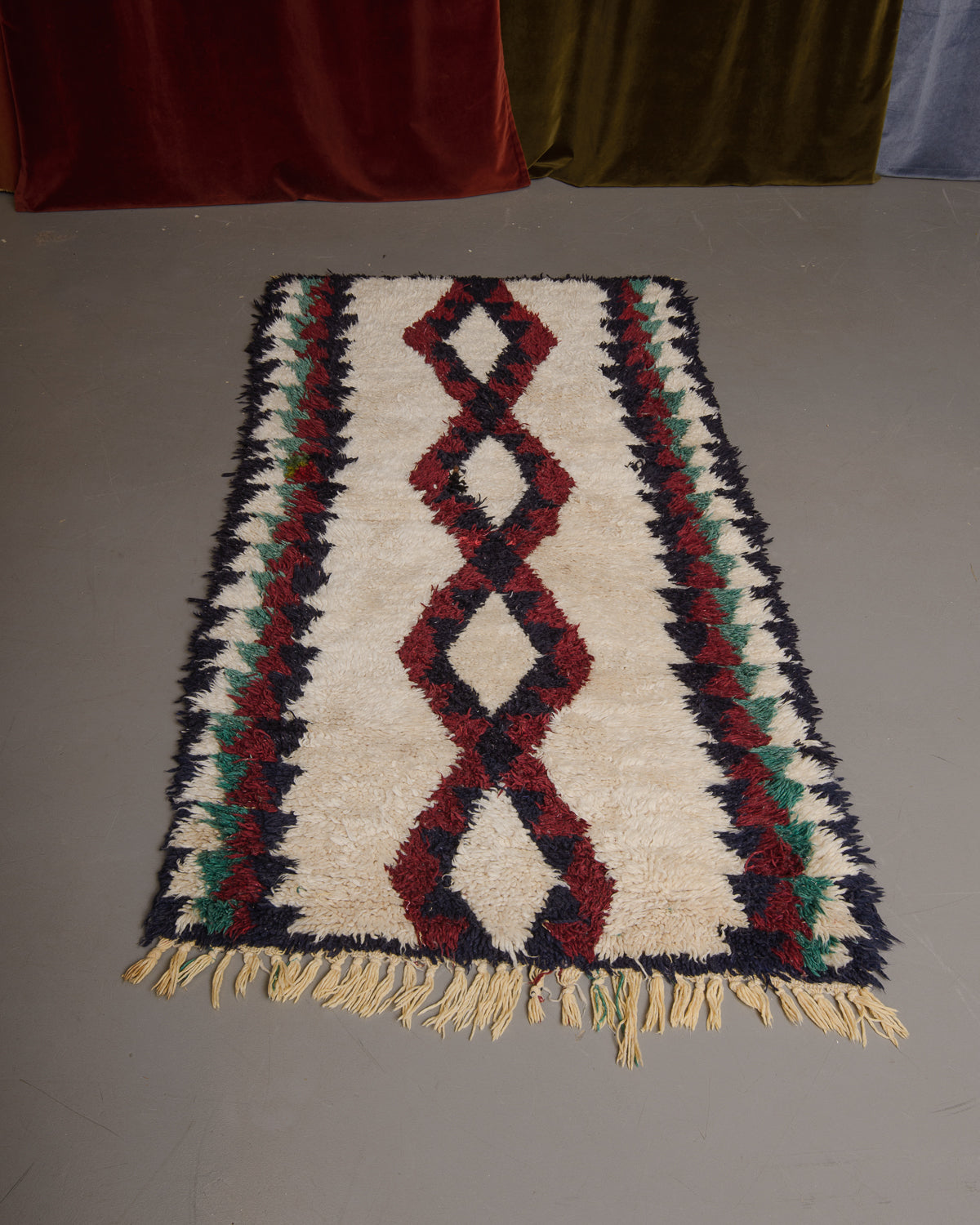 Vintage Berberlin boucherouite runner rug on grey floor.