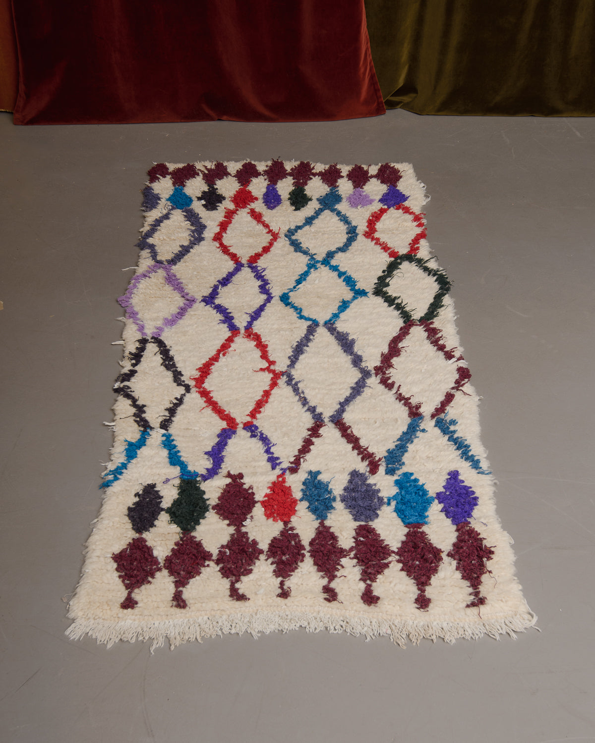 Vintage Berberlin boucherouite runner rug on grey floor.