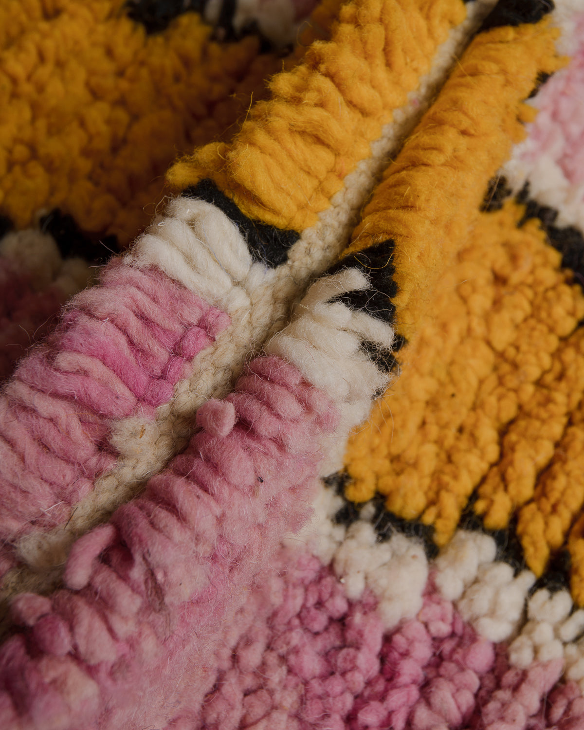 Close up of Boujaad rug with blue, black, taupe, red, orange and cream wool.