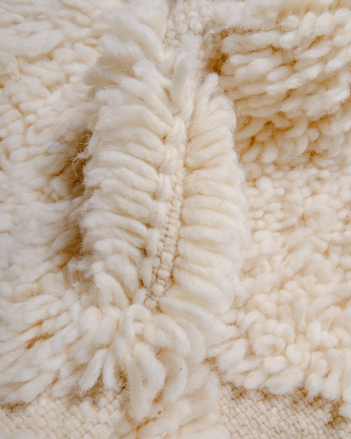 Detail of fluffy cream wool pile of Berber rug.