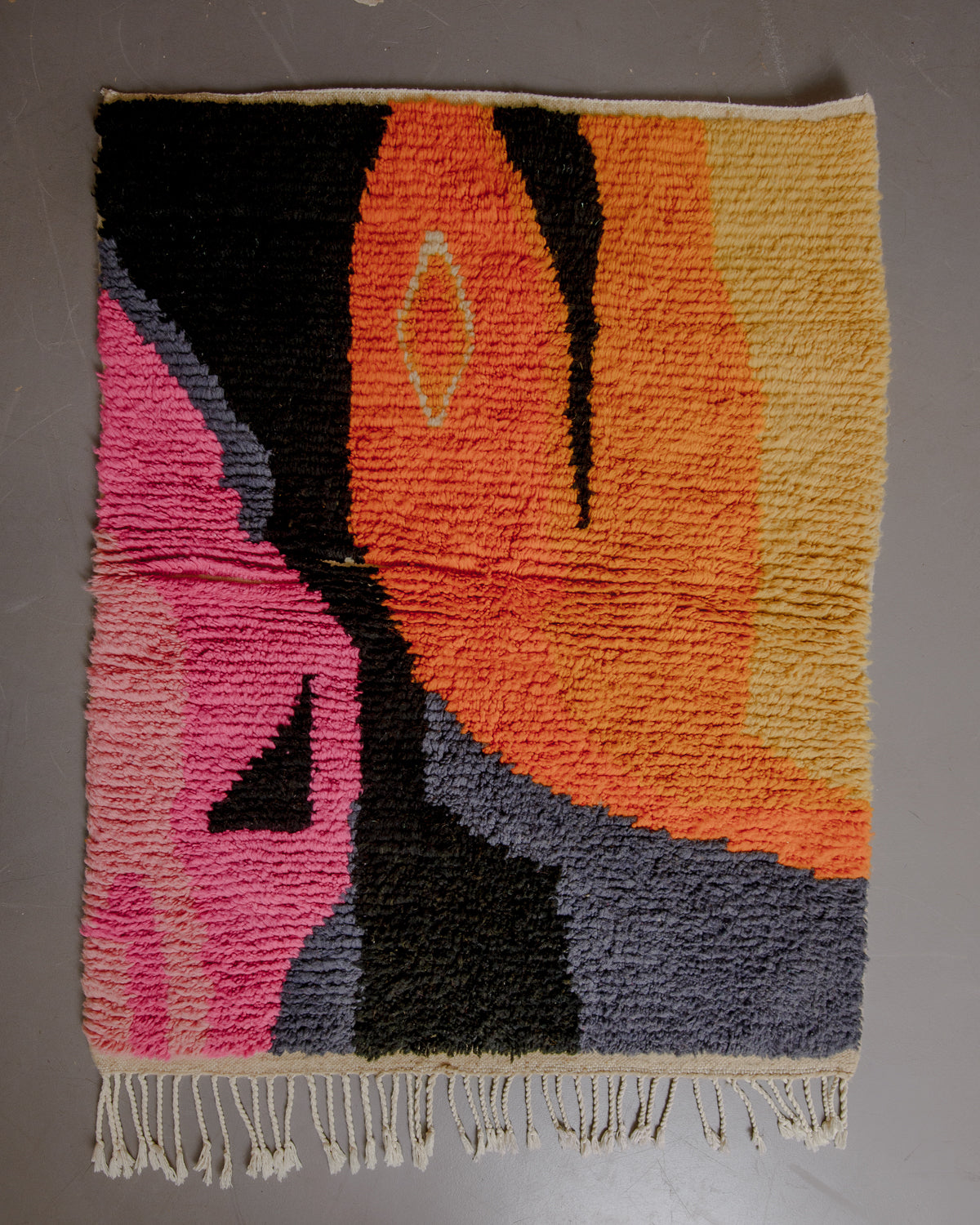 Vintage boujaad rug on grey floor.
