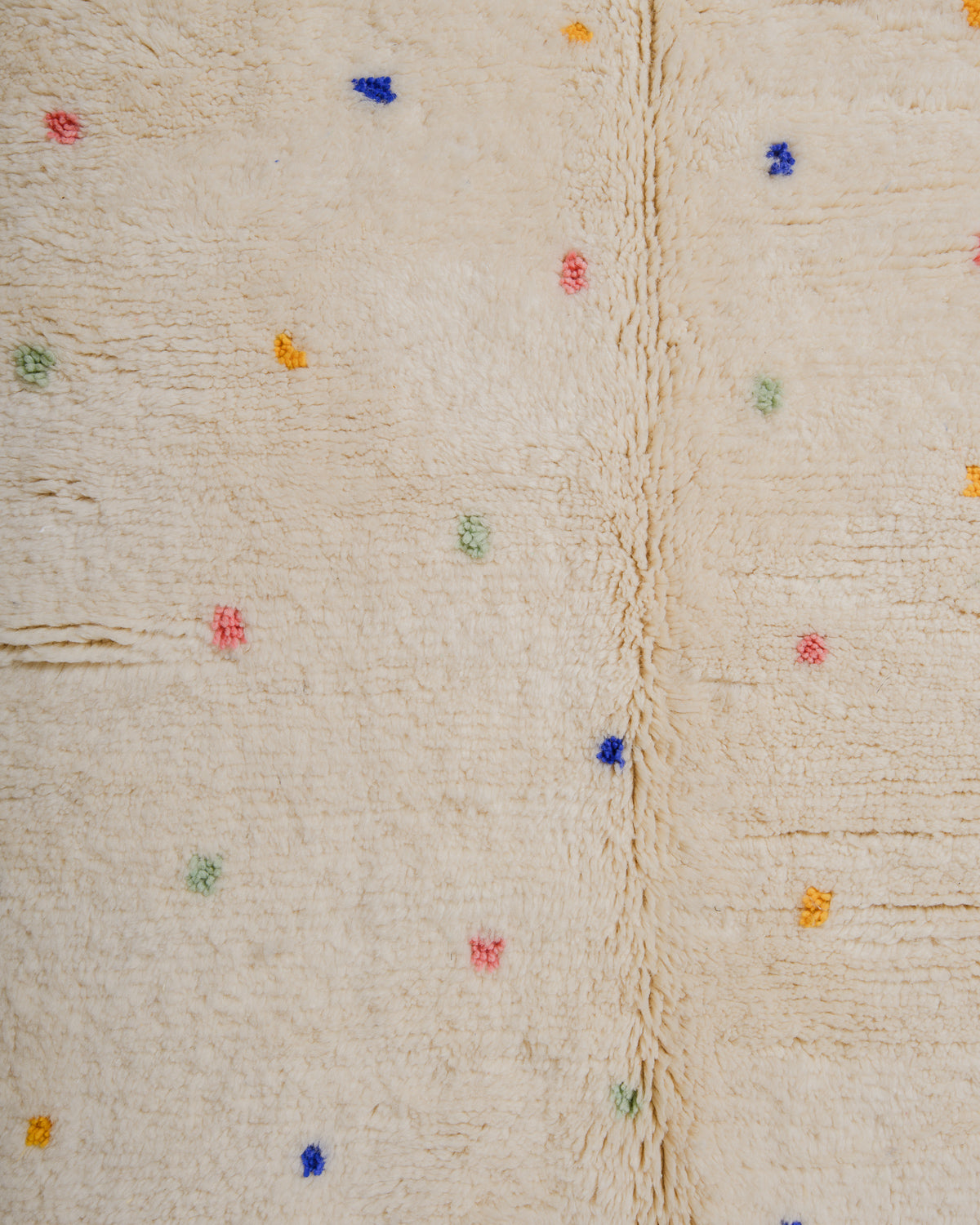 Surface of wool rug with colourful dots and a thick pile.