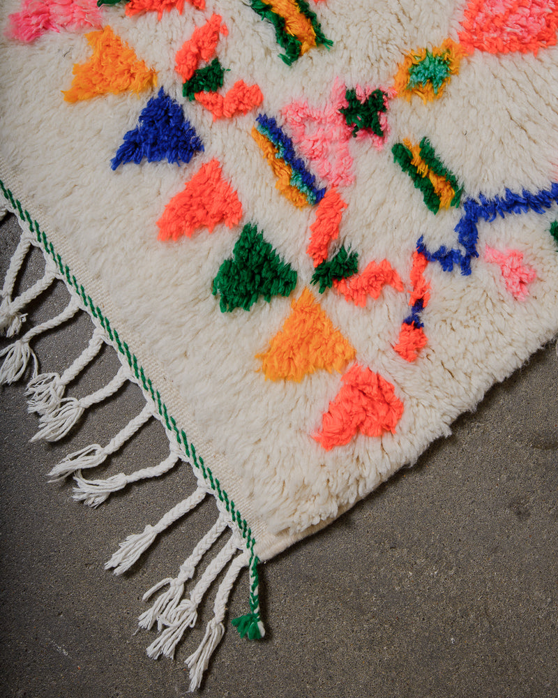 Colourful woven rug with geometric patterns on a neutral background