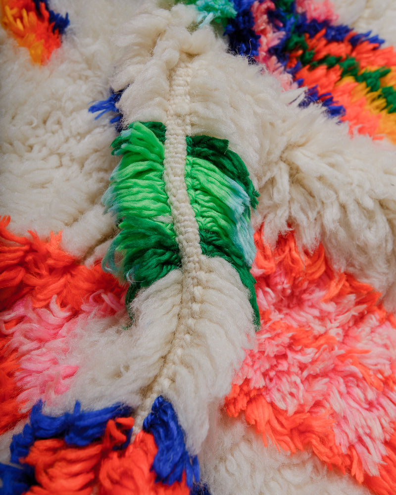 Close up of azilal rug showing fluffy pile made of cream wool and colourful cotton. 