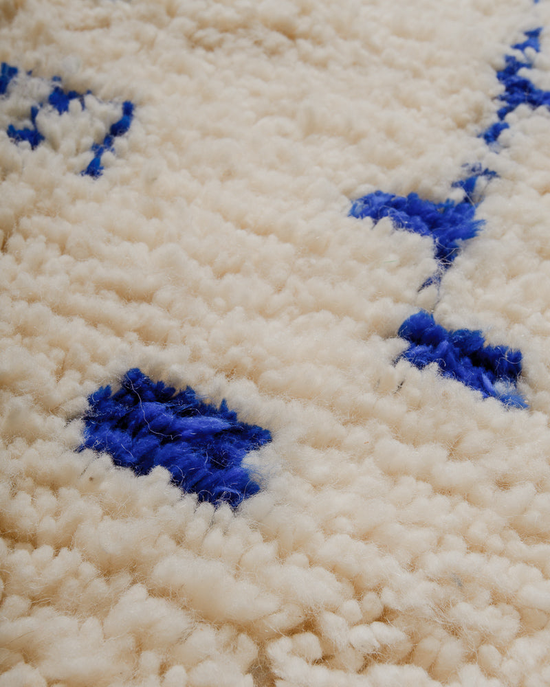 Close up of Berberlin Azilal rug with cream sheep's wool and blue cotton.