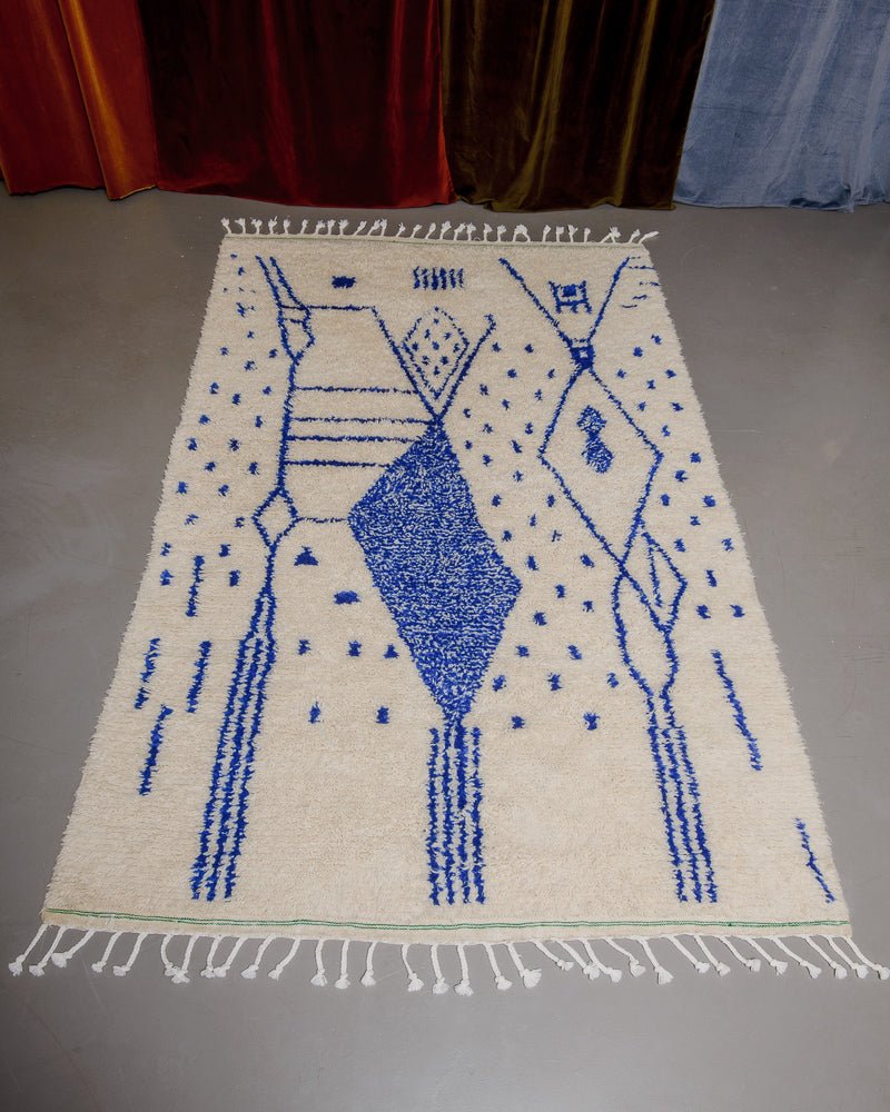 blue and cream azilal rug on grey floor. 