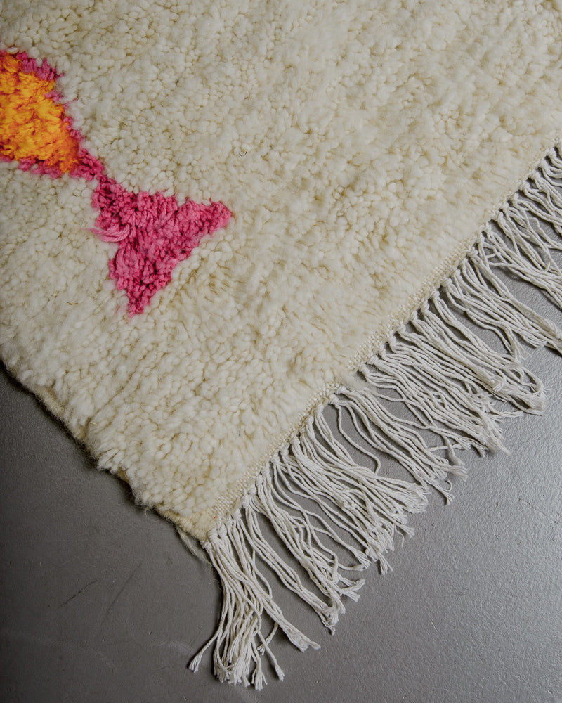 Corner of azilal rug with white cotton fringe.